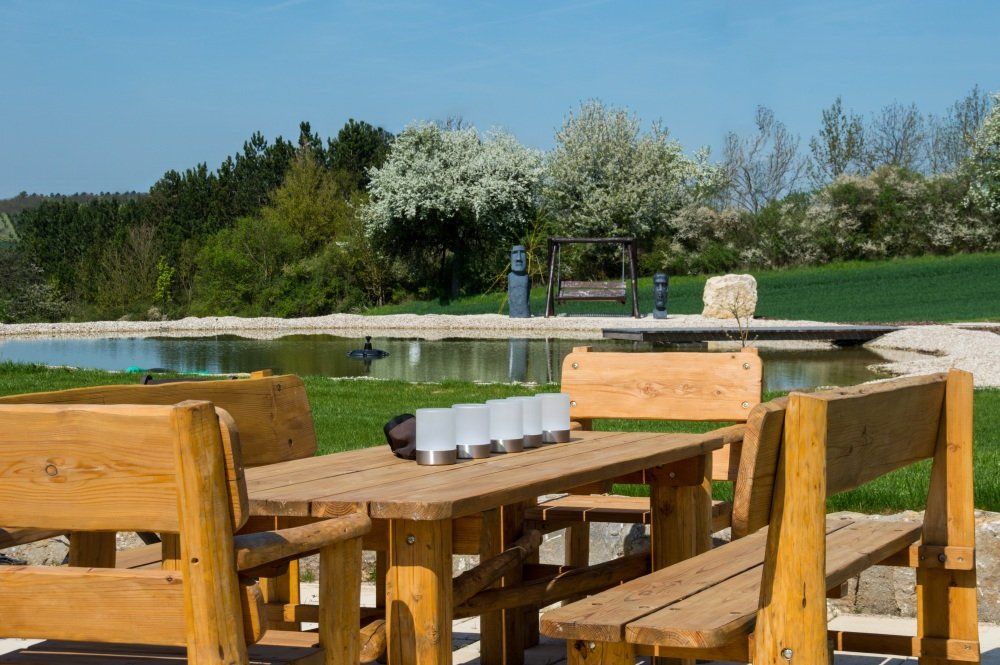 Großer Gartenteich mit Holztisch-Garnitur, Steg und Hollywoodschaukel.