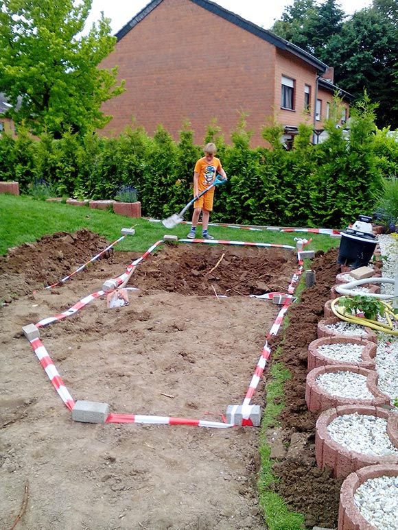 Mit Absperrband und Ziegelsteinen werden die Teichumrisse makiert.